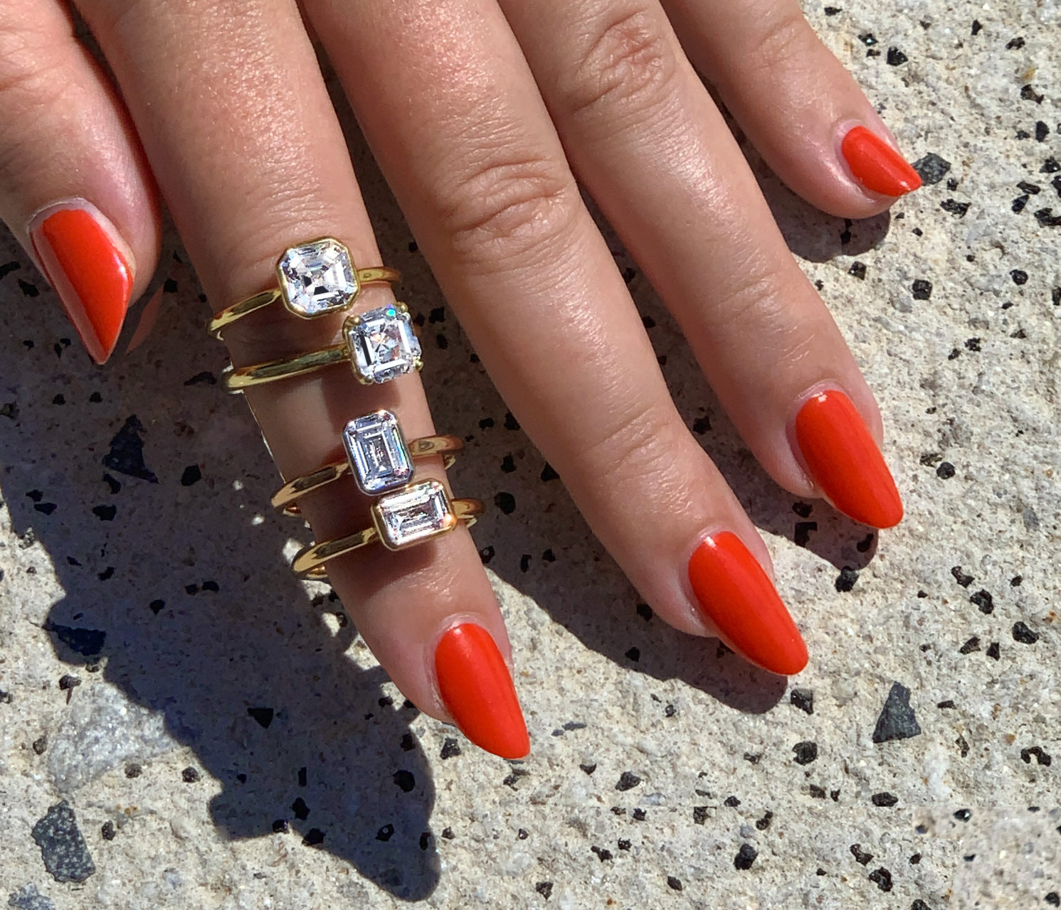 Woman showcasing four placeholder engagement rings