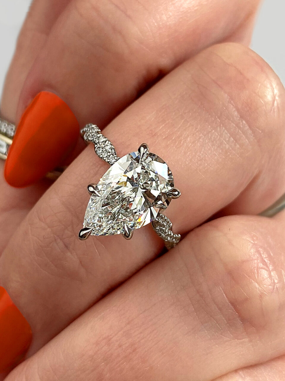 Frank Darling custom pear claw prong engagement ring with a twisted pavé band